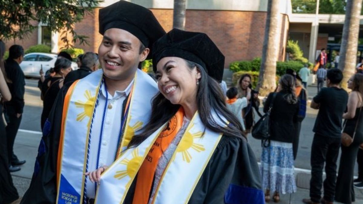 two students in graduation attire